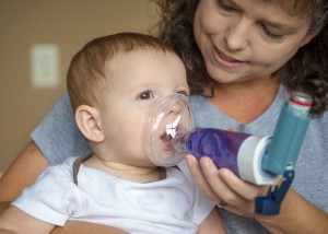 Infant getting breathing treatment from mother while suffering from illness