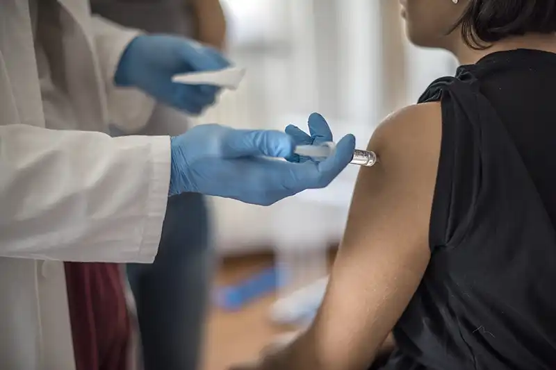 close up of woman getting vaccine at urgent care
