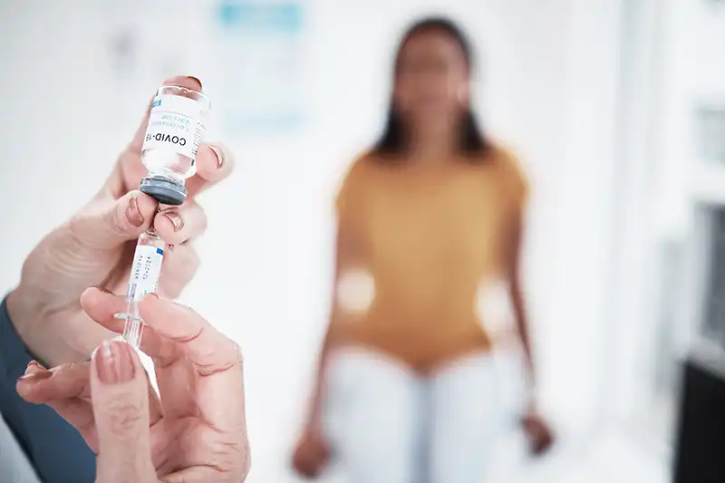 doctor making flu shot while patient waits in background