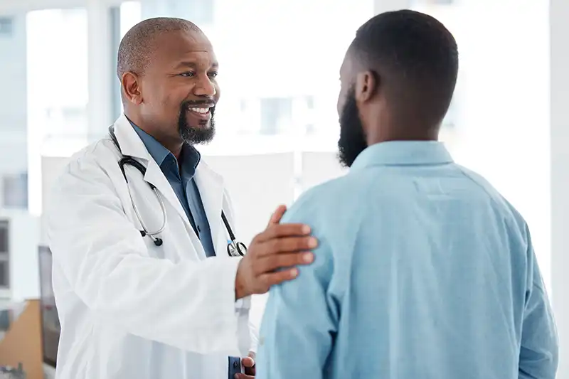 doctor smiling at man getting immigration medical exam