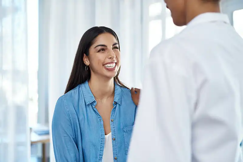 smiling young female patient with doctor after immigration exam