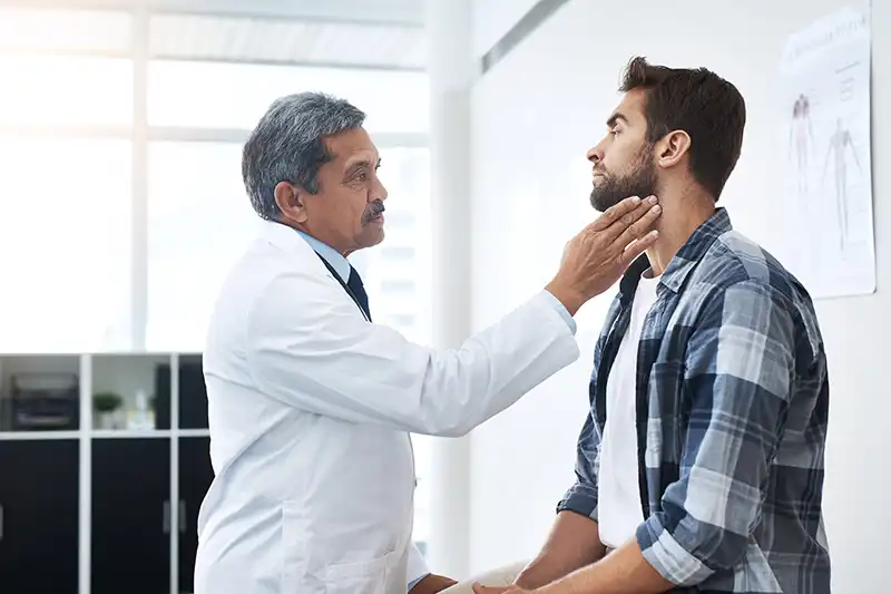young man with sore throat and doctor at urgent care