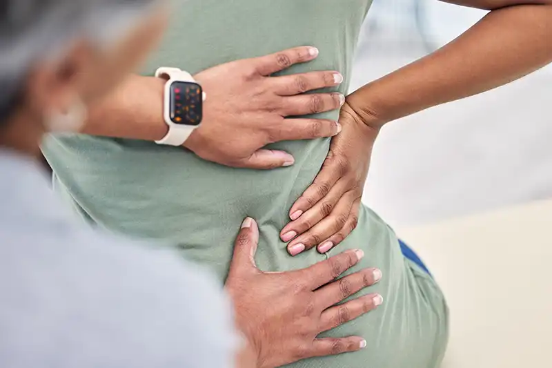 chiropractor checking patients back pain at urgent care