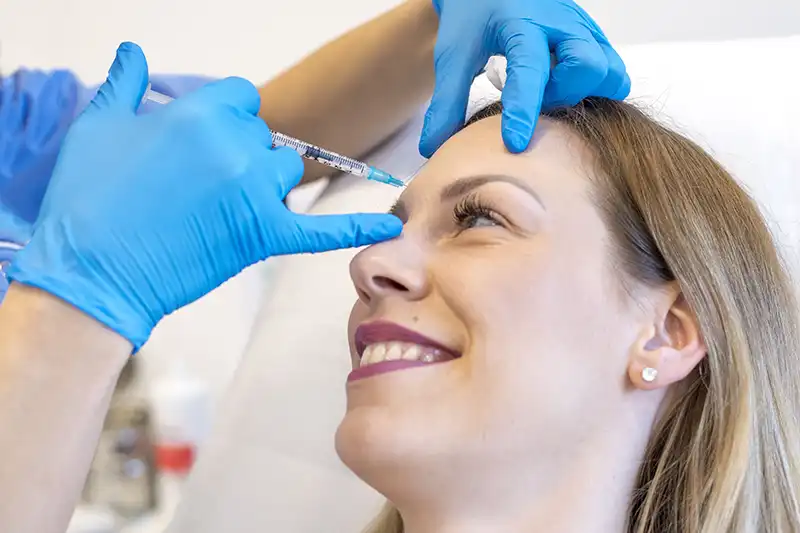 close up of doctor injecting botox into patients forehead wrinkles