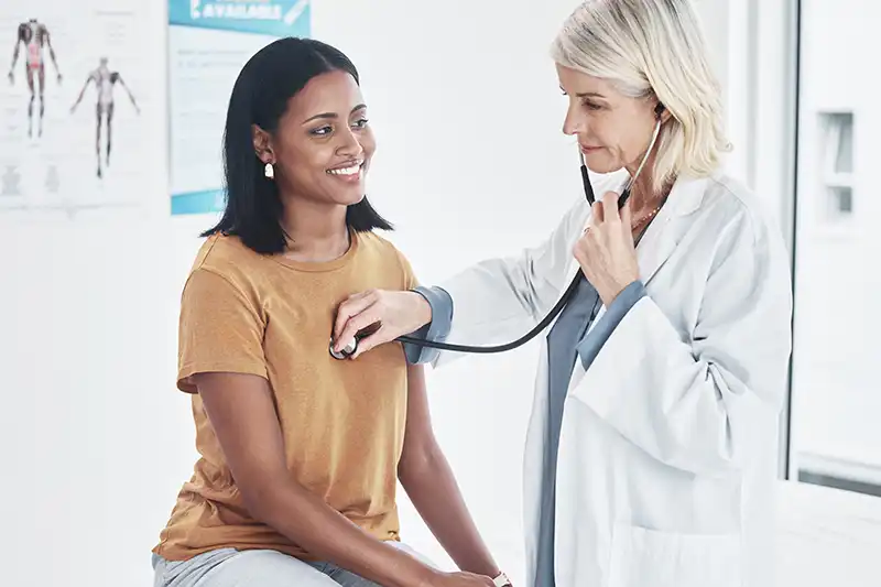 woman doctor giving medical clearance exam to patient